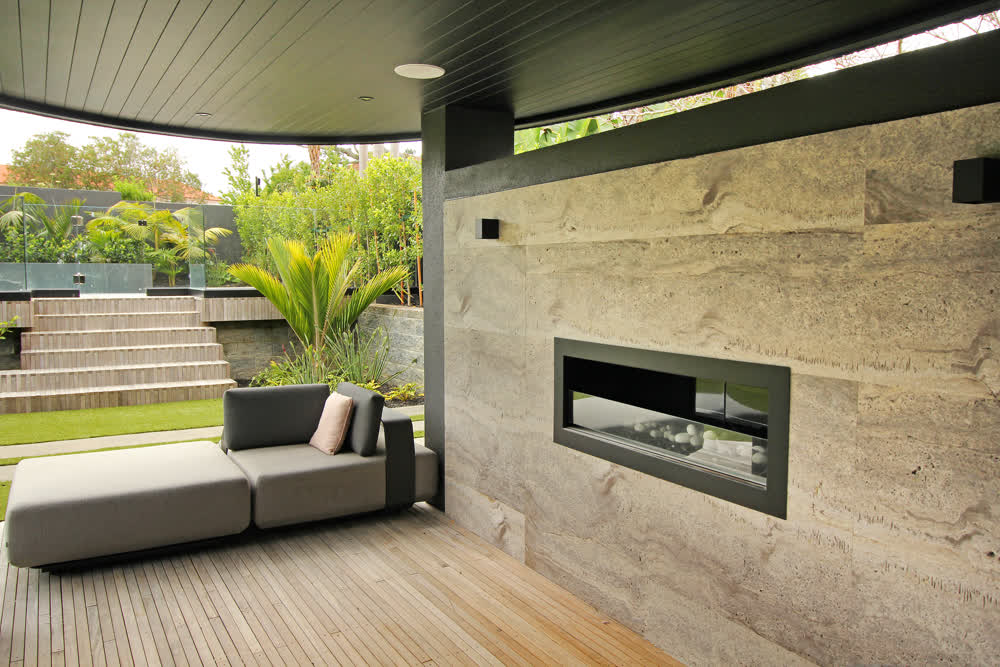 Designed outdoor area with fireplace, pool, and hedging